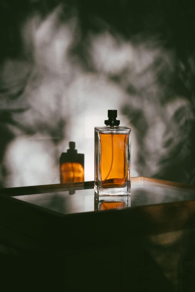 Amber perfume bottle and its reflection — illustrative photography