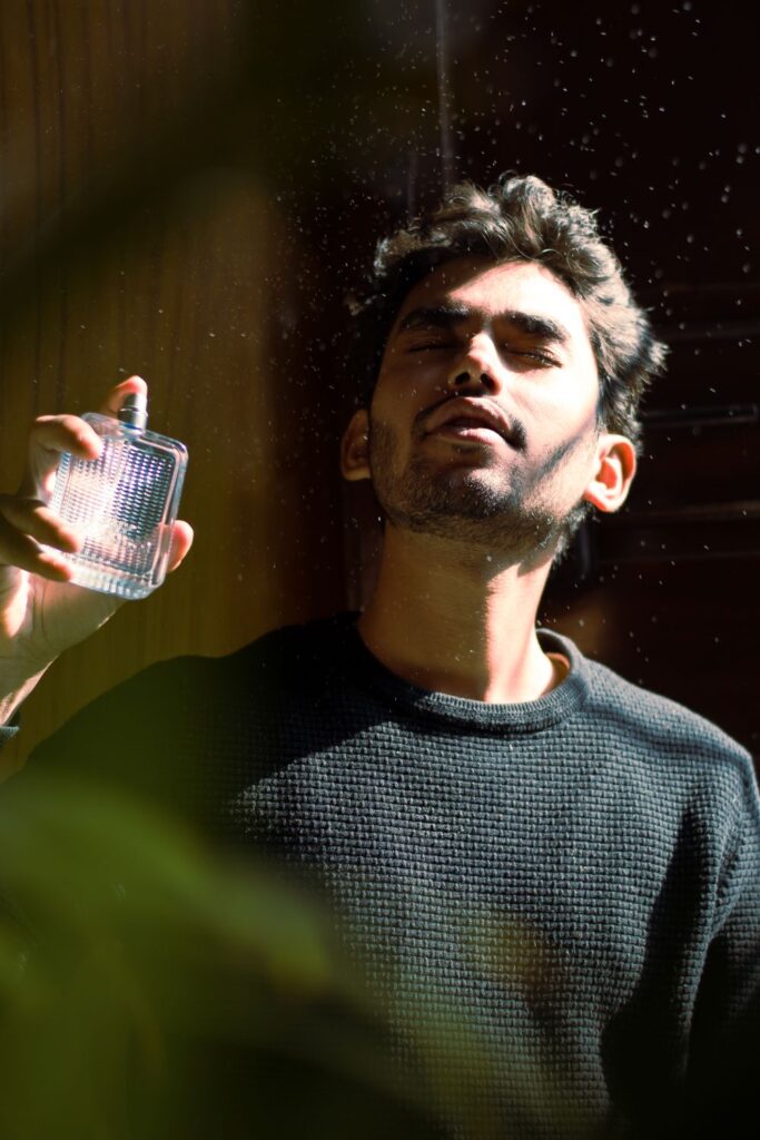 Man applying perfume in warm light
